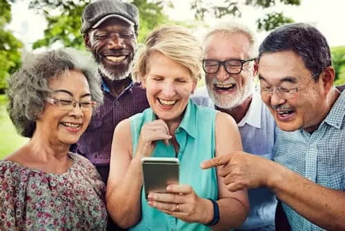 senior friends sharing a mobile phone